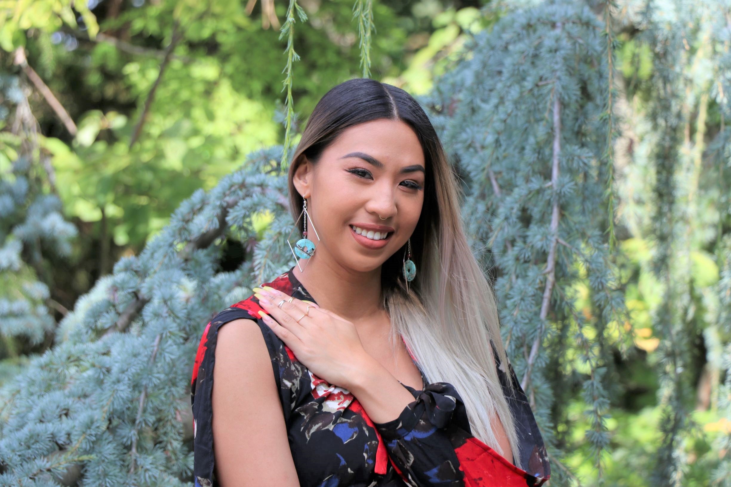 Model wearing stackable rings and turquoise diamond earrings